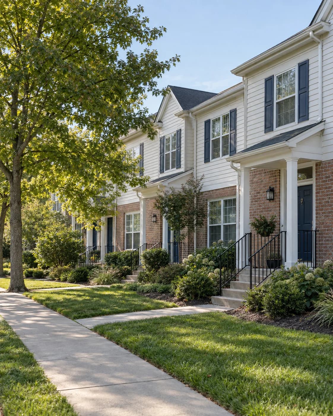 US townhomes with shared sidewalks, brick porches, and landscaped grounds